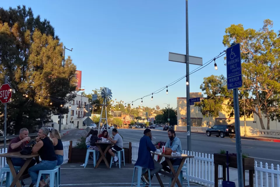 Outdoor dining patio in street in Echo Park neighborhood of Los Angeles, surrounded by white picket fence